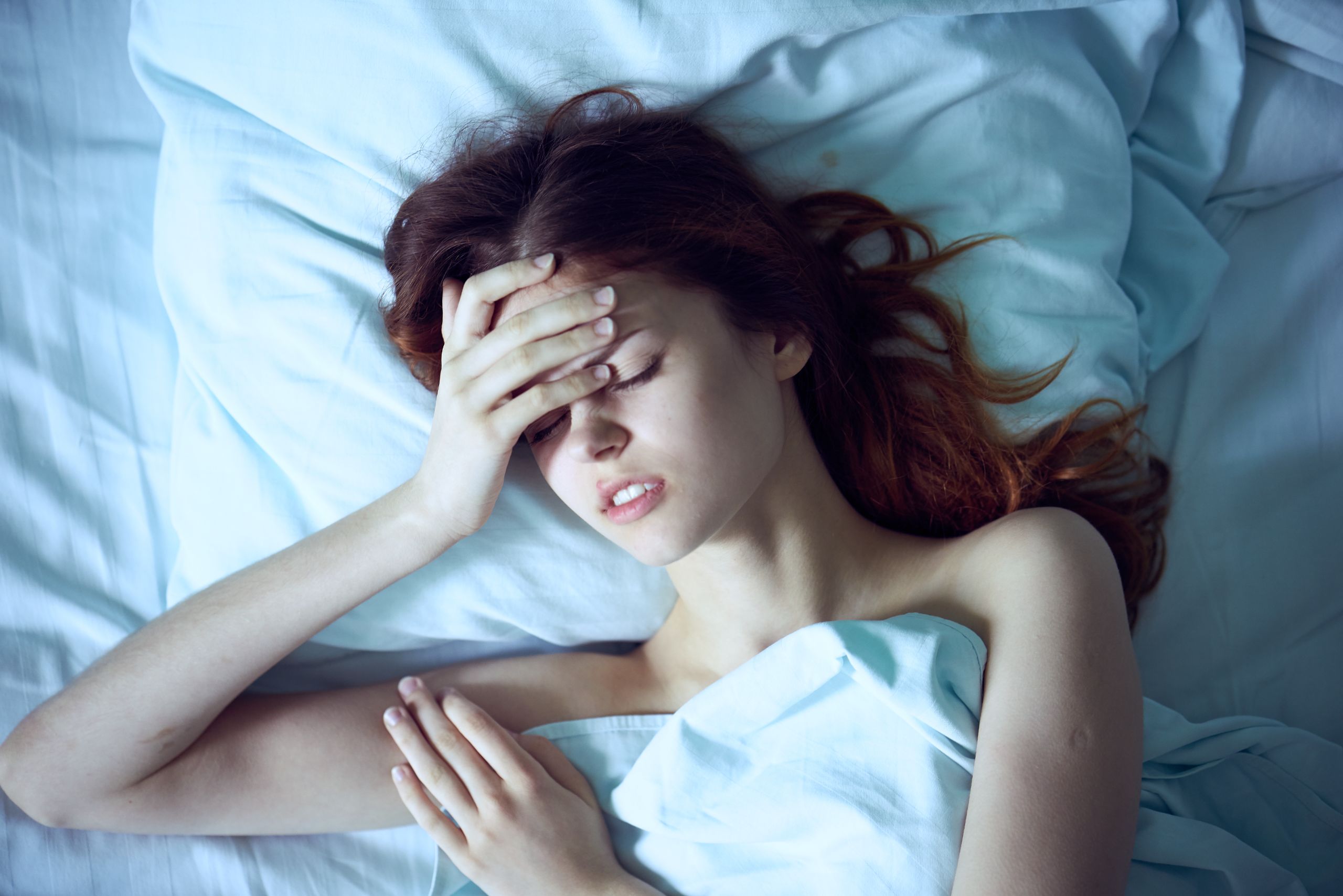 Woman lies in bed, bedroom, rest, headache, portrait, morning