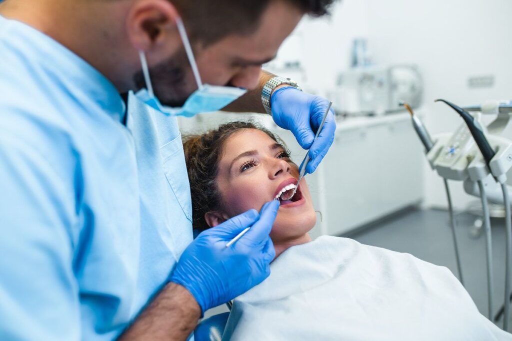 Dentist performing an oral cancer screening exam on a patient
